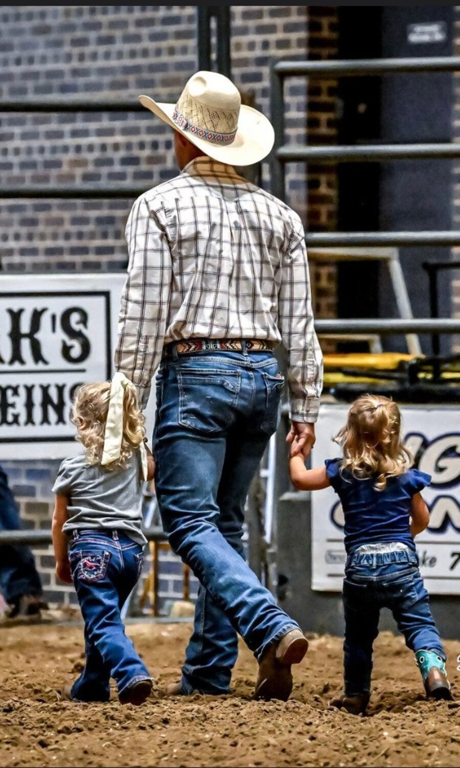 Jon Anderson walking with his daughters at a rodeo